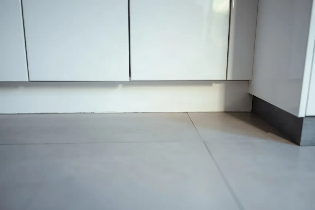 Base dei mobili di una cucina, con lo zoccolo e una fessura sottile sopra le piastrelle